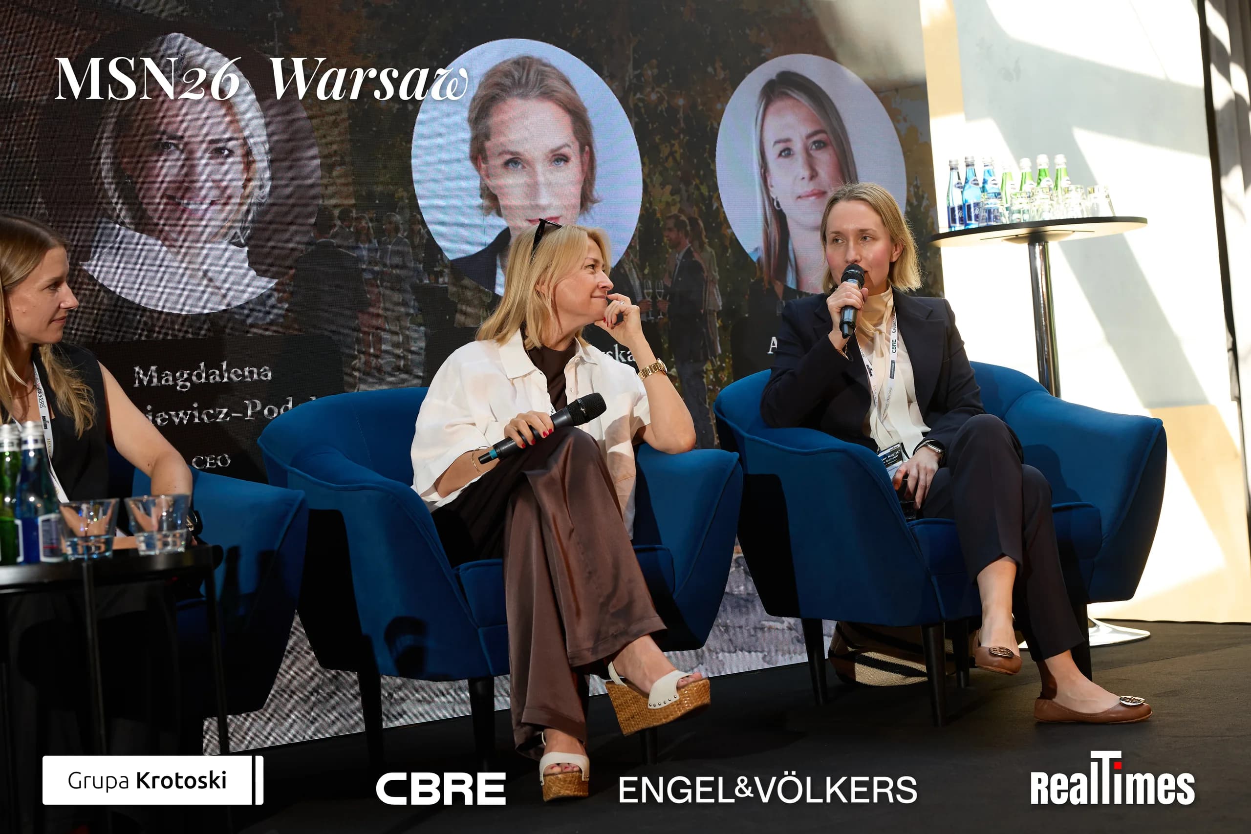 Mid-Summer Night 2026 at B'Fort, Warsaw: three panelists seated, mic, same panel