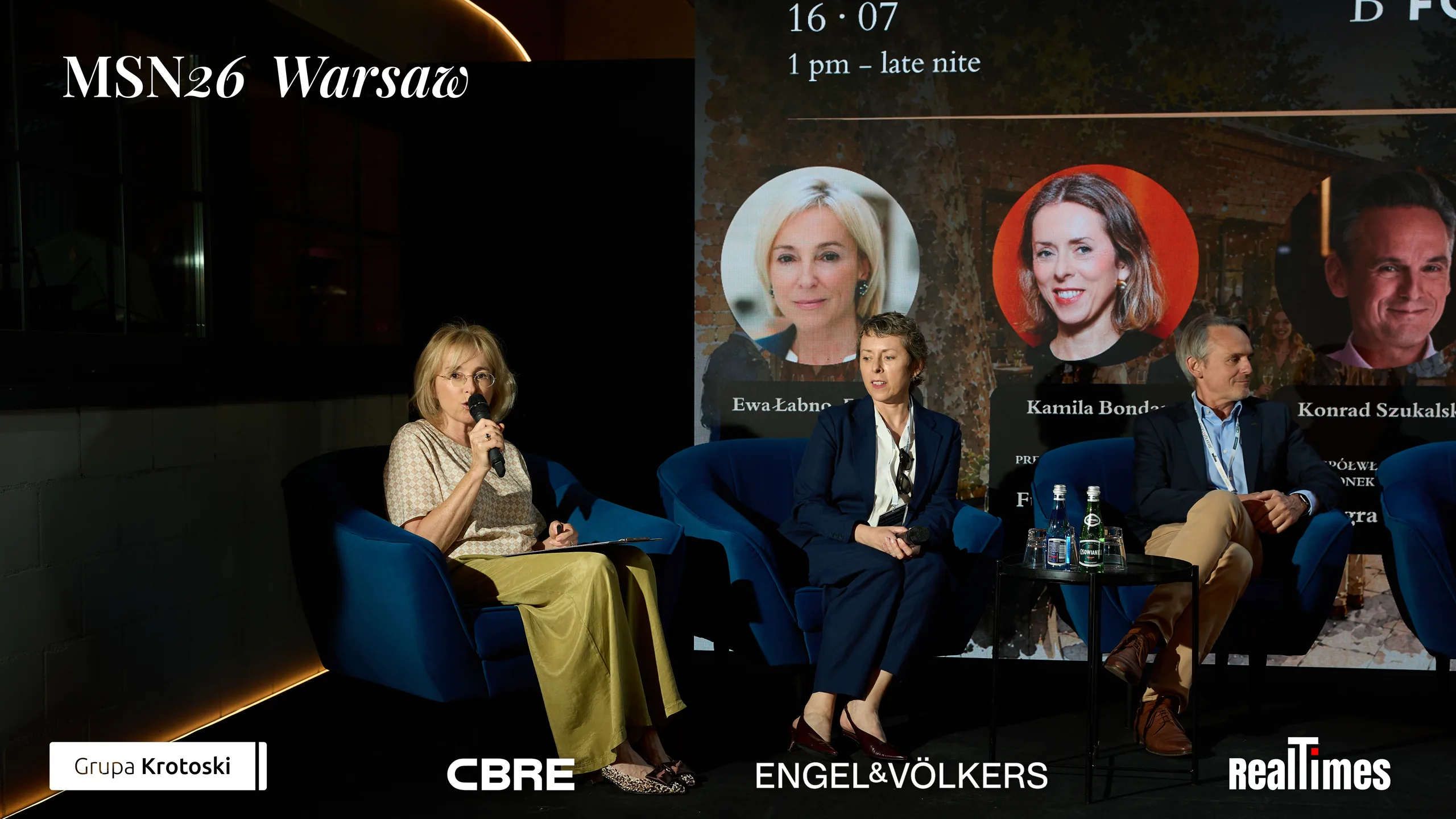 Mid-Summer Night 2026 at B'Fort, Warsaw: moderator with mic plus panelists on stage