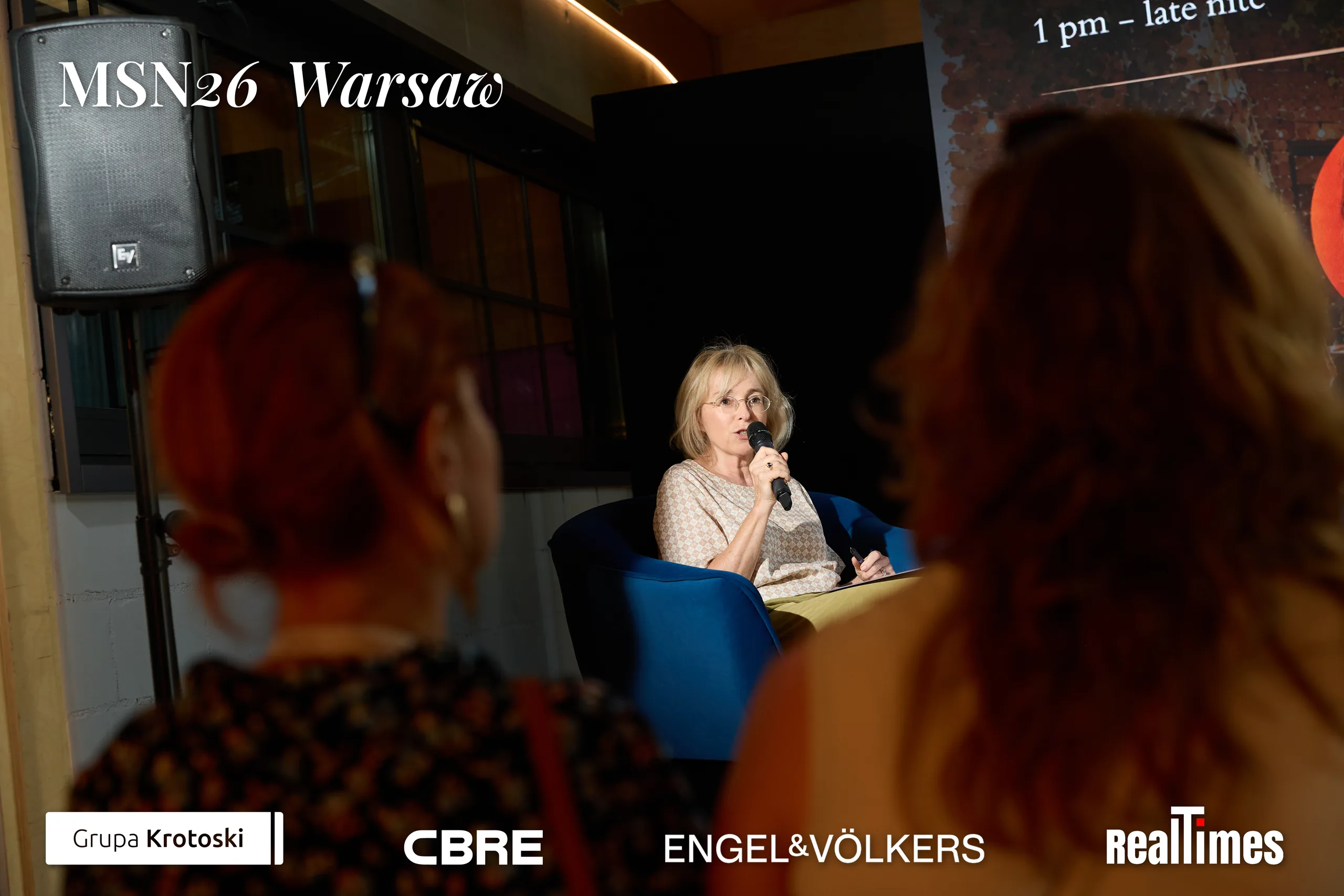 Mid-Summer Night 2026 at B'Fort, Warsaw: moderator with mic, audience foreground