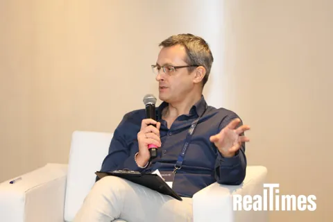 Alexander Morari putting a question to the panel, both hands open, at PropTech Connect Middle East 2026 in Dubai.
