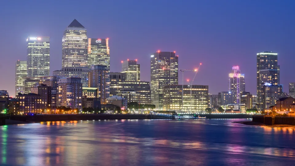 Canary Wharf office towers across the Thames at dusk, a London district where Gulf investors buy offices