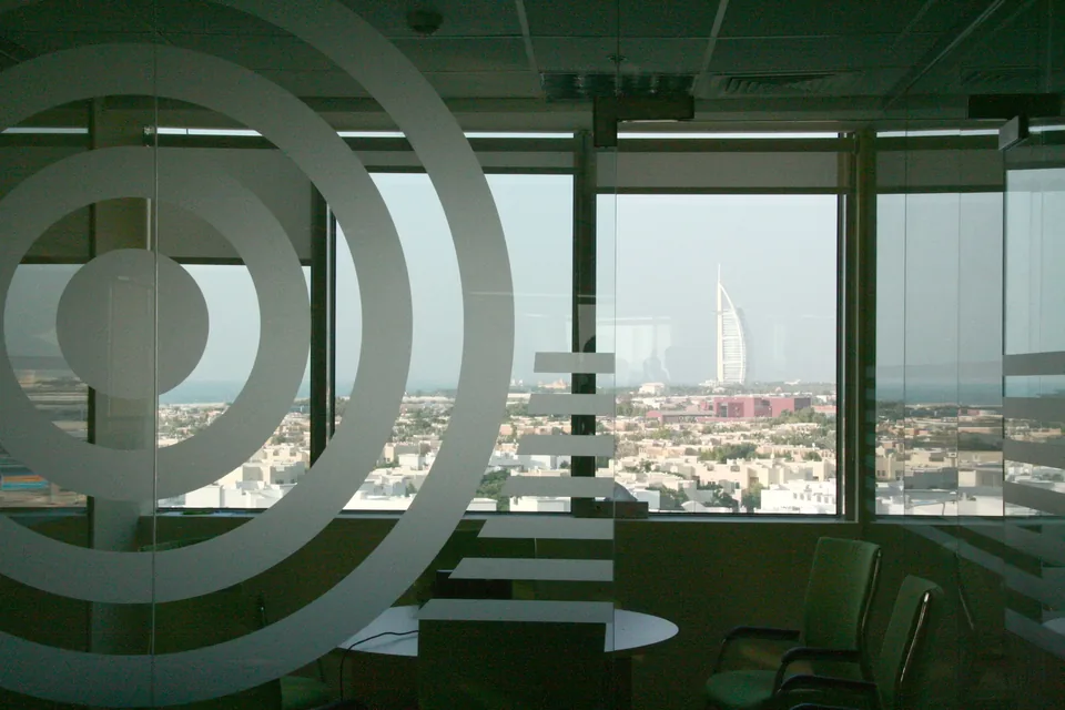 A fitted Dubai office floor with glazed partitions and a view toward the Burj Al Arab, the kind of space flex operators take over