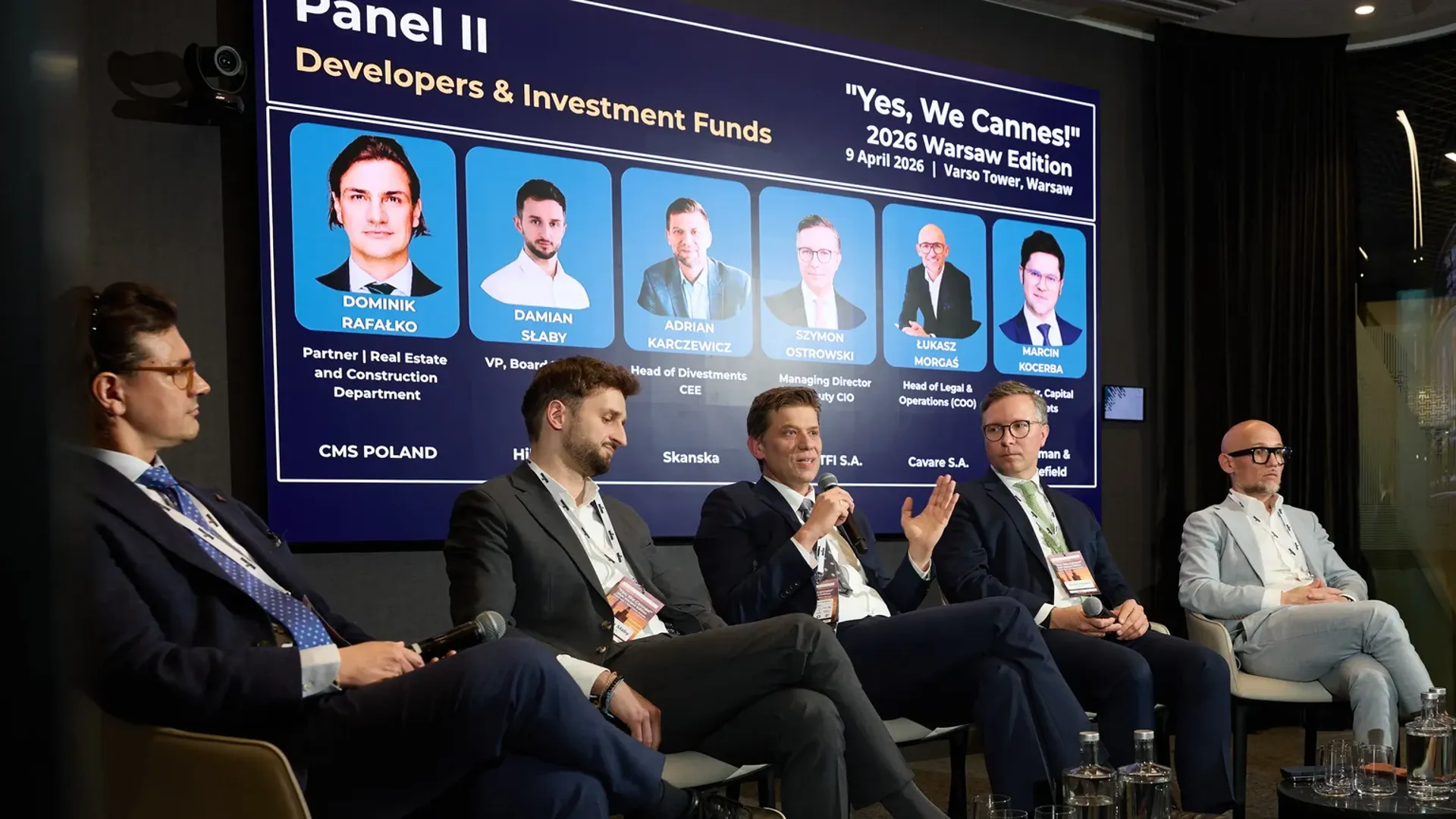 Panel dyskusyjny na scenie wydarzenia RealTimes w Warszawie, prelegenci przed publicznością