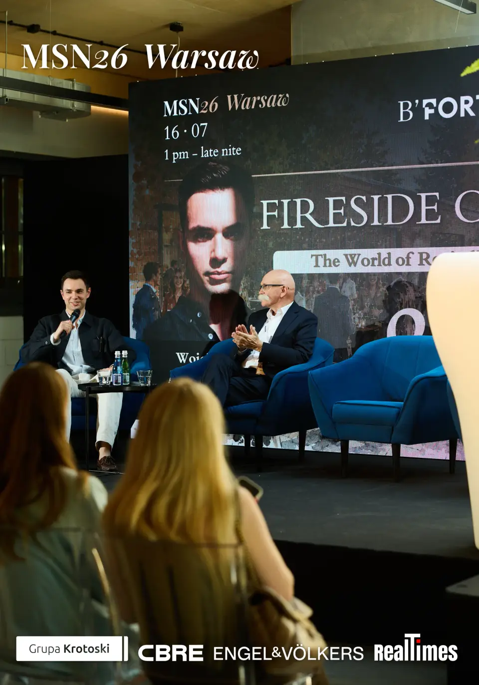 Mid-Summer Night 2026 at B'Fort, Warsaw: Fireside Chat screen, two in armchairs