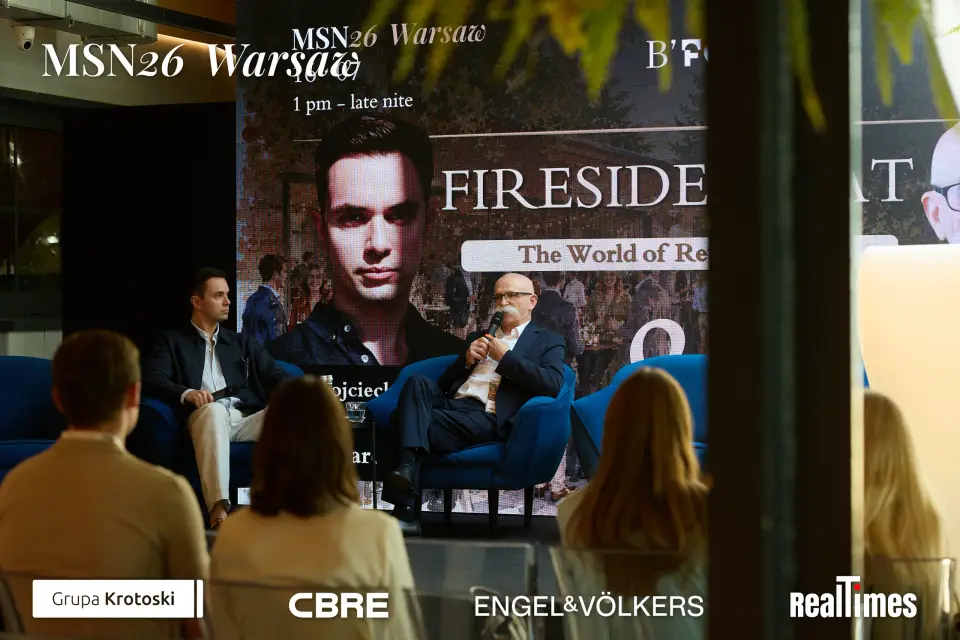 Mid-Summer Night 2026 at B'Fort, Warsaw: Fireside Chat screen, two on stage, audience