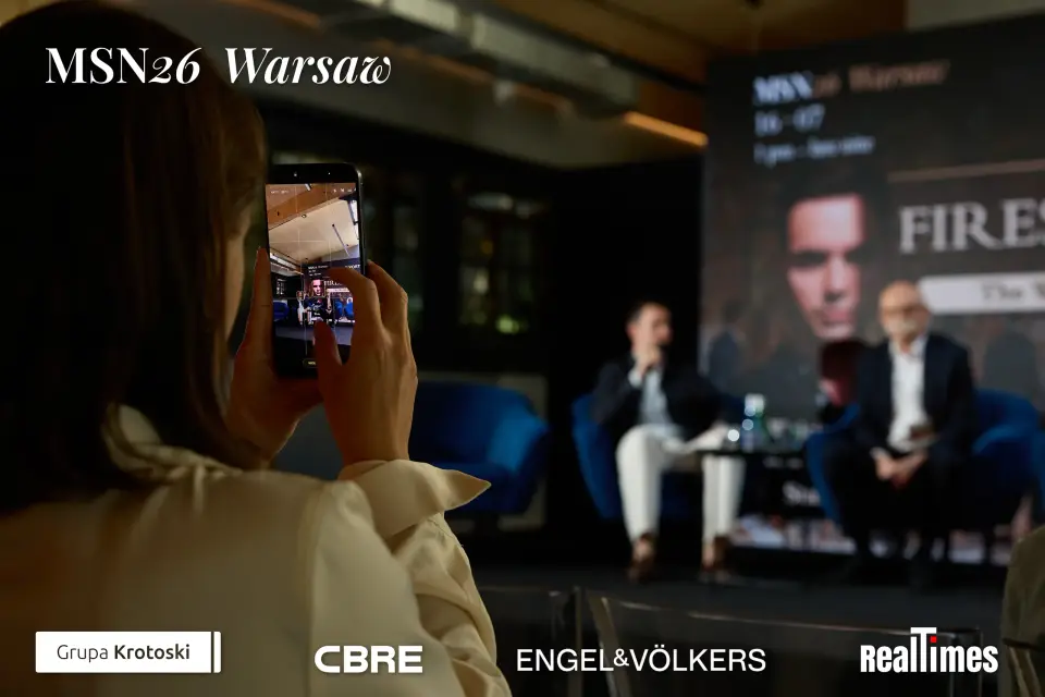Mid-Summer Night 2026 at B'Fort, Warsaw: attendee films fireside stage, two seated