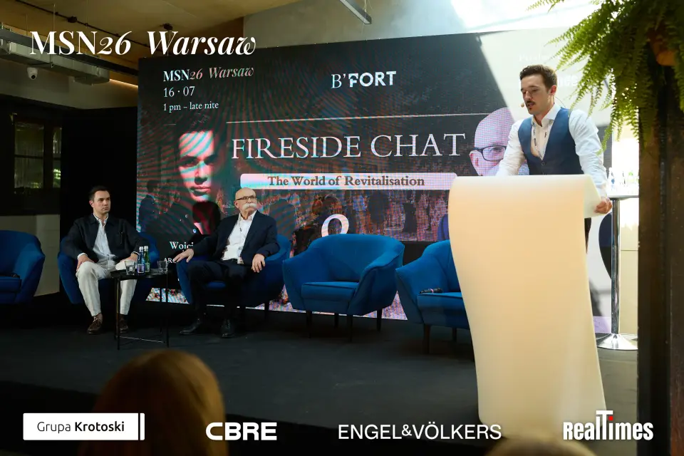 Mid-Summer Night 2026 at B'Fort, Warsaw: Fireside Chat screen, two seated plus lectern intro