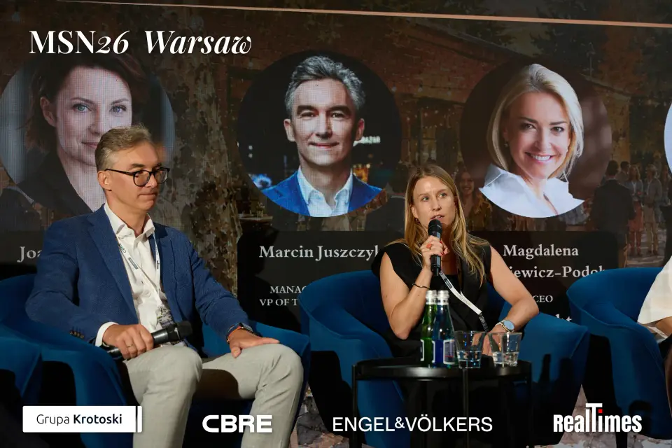 Mid-Summer Night 2026 at B'Fort, Warsaw: two panelists on stage, Juszczyk card