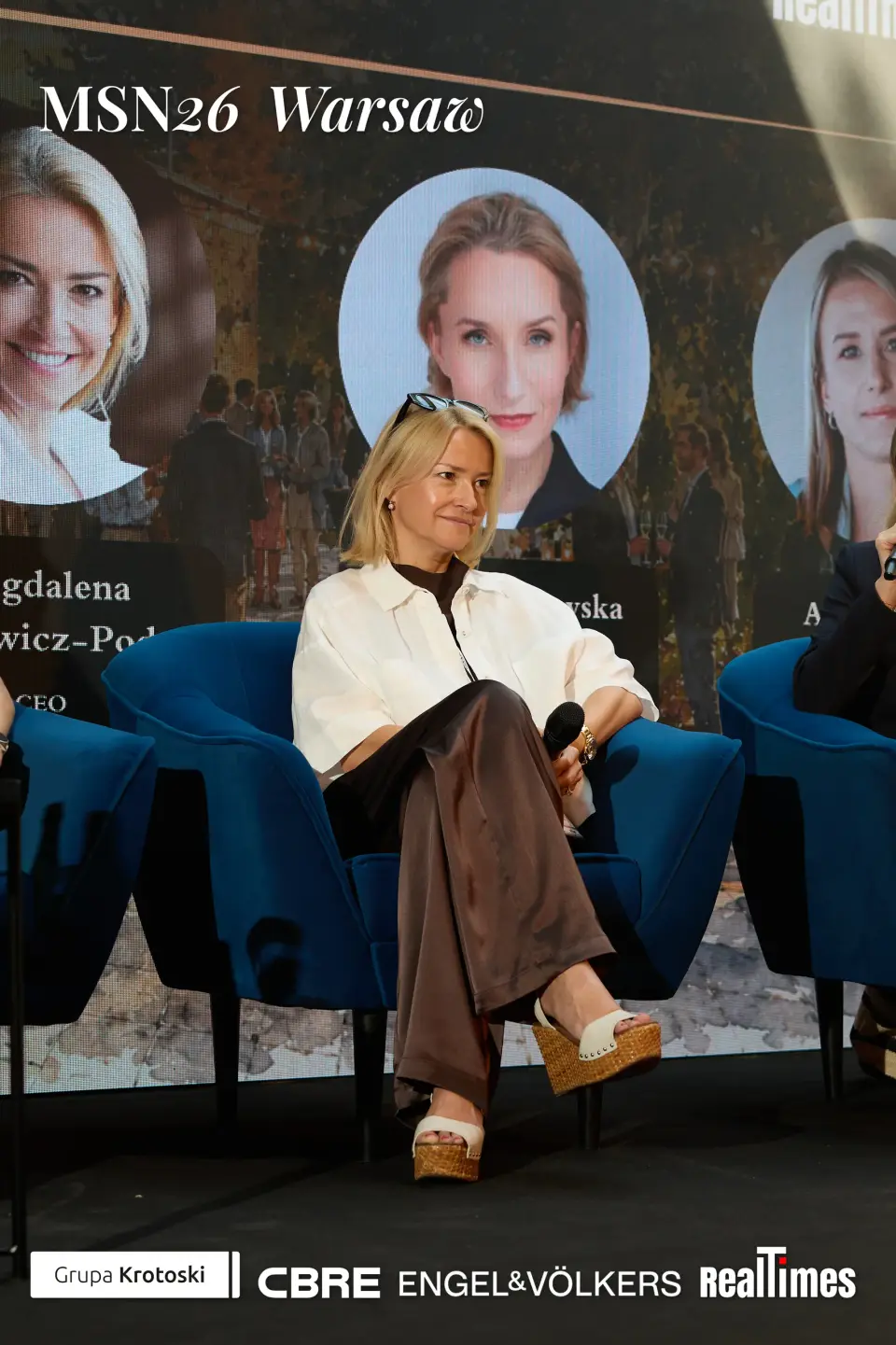Mid-Summer Night 2026 at B'Fort, Warsaw: panelist seated on stage, speaker cards behind