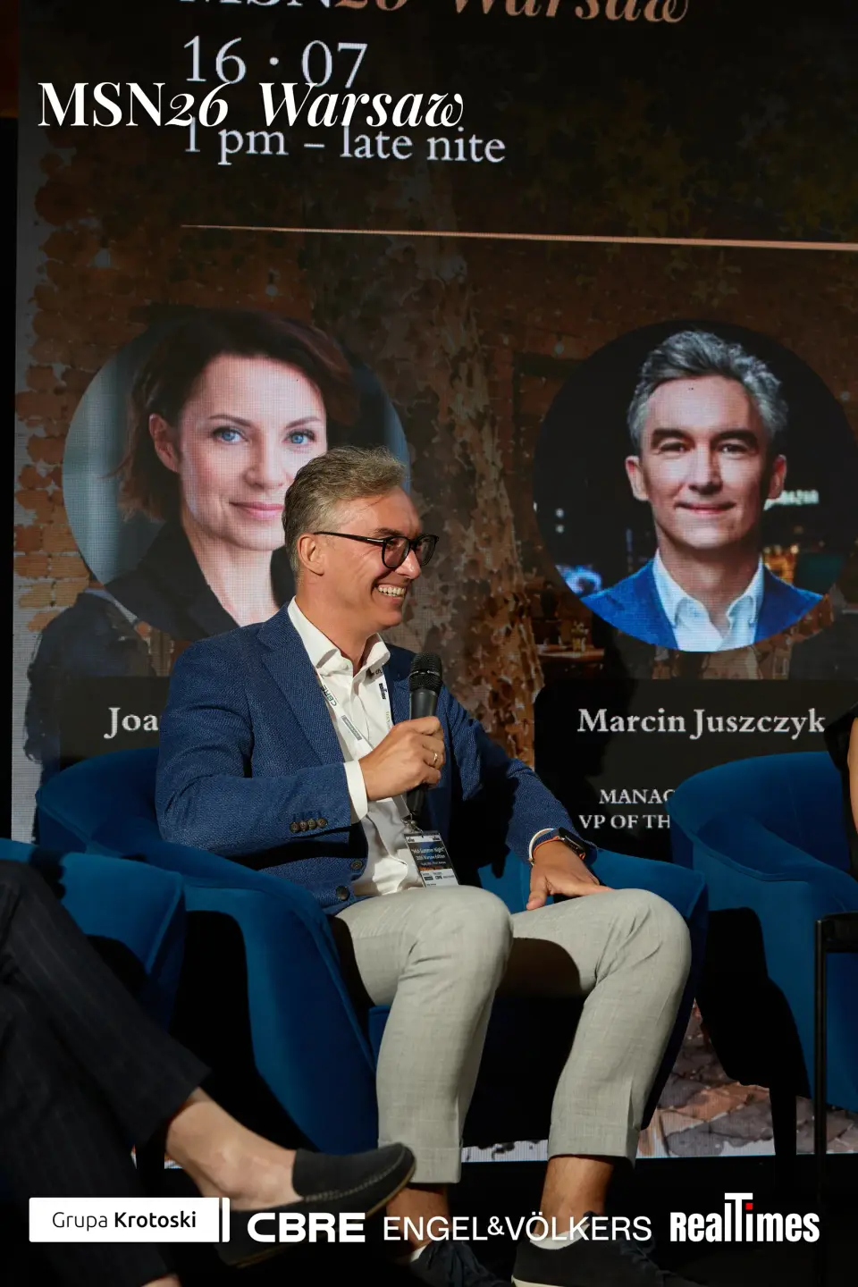 Mid-Summer Night 2026 at B'Fort, Warsaw: panelist speaking, Mroczek/Juszczyk cards