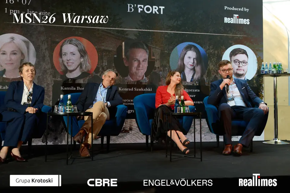 Mid-Summer Night 2026 at B'Fort, Warsaw: panelists row, headshot screen behind