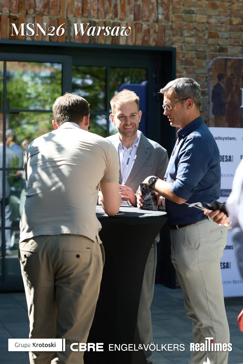 Mid-Summer Night 2026 at B'Fort, Warsaw: three men networking outdoors at table