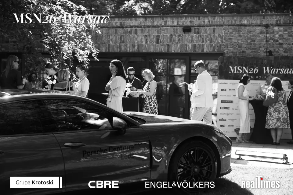 Mid-Summer Night 2026 at B'Fort, Warsaw: networking near Porsche, sponsor wall, B&W