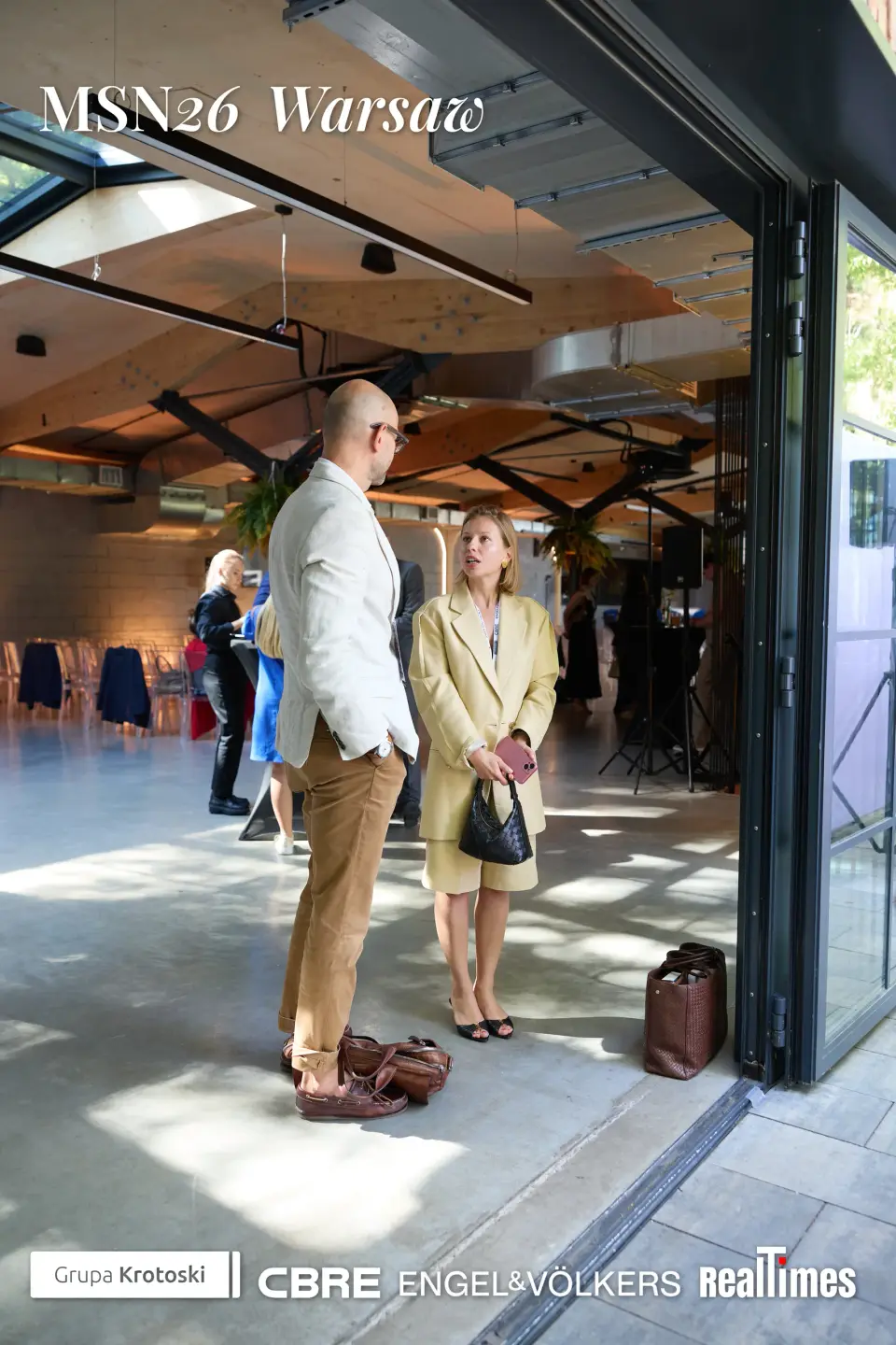Mid-Summer Night 2026 at B'Fort, Warsaw: guests chatting indoors by the open glass doors