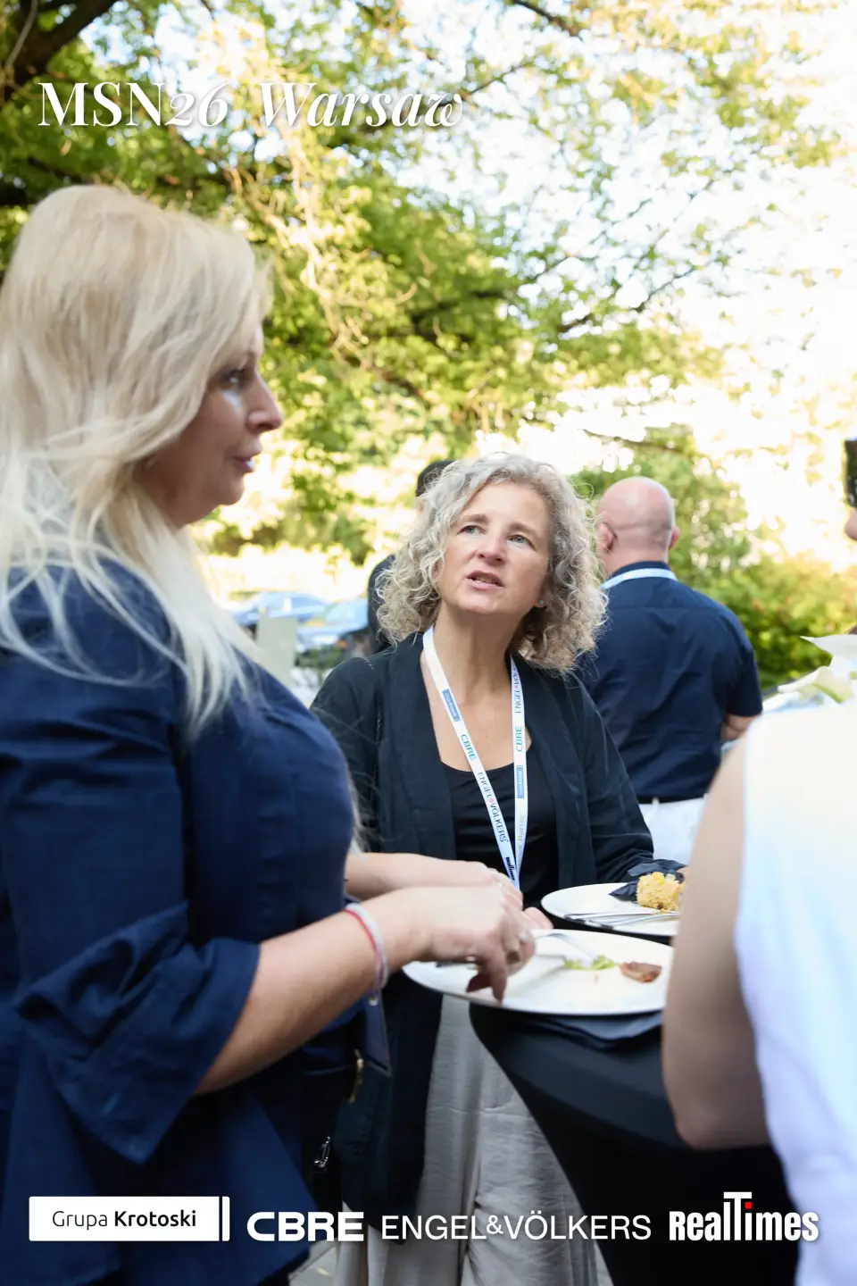 Mid-Summer Night 2026 at B'Fort, Warsaw: women chatting with plates, garden networking