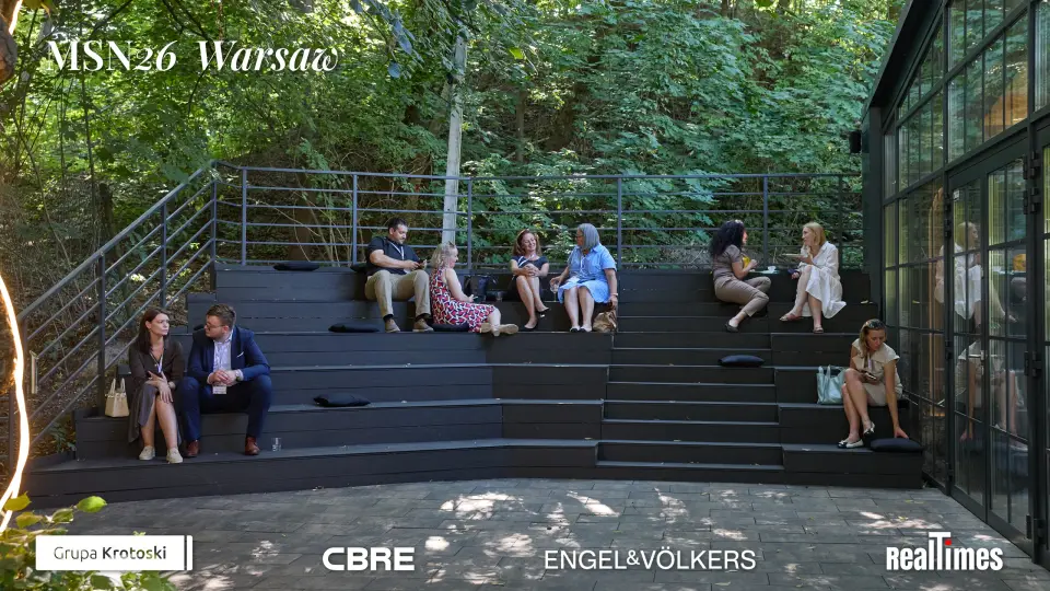 Mid-Summer Night 2026 at B'Fort, Warsaw: two seated on stage with mics, blue armchairs | QA-adjudicated: networking/posed portrait, not stage